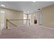 Hallway featuring plush carpeting, neutral walls, and a wooden banister overlooking the stairwell at 1137 Misty Valley Ct, Lawrenceville, GA 30045