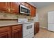 Well-lit kitchen featuring stainless steel microwave, white oven range, and beautiful backsplash at 1137 Misty Valley Ct, Lawrenceville, GA 30045