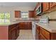 Kitchen with wood cabinets, tile countertops, island, and sliding glass doors to the backyard at 1137 Misty Valley Ct, Lawrenceville, GA 30045