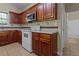 Kitchen with wood cabinets, tile countertops, and standard white appliances at 1137 Misty Valley Ct, Lawrenceville, GA 30045