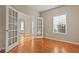 Bright home office with hardwood floors, a large window with blinds, and glass paneled doors at 1137 Misty Valley Ct, Lawrenceville, GA 30045