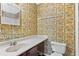 Bathroom with floral wallpaper, sink, and toilet at 124 Camelot Dr, Atlanta, GA 30349