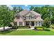 Elegant brick and stone home with manicured lawn and lush landscaping provides great curb appeal at 2230 Cambridge Hill Ct, Dacula, GA 30019