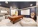 Stylish game room with a billiards table, projector screen, and comfortable seating, perfect for entertaining at 2230 Cambridge Hill Ct, Dacula, GA 30019