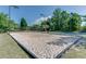 The community's volleyball court is surrounded by trees and features lighting for nighttime activities at 2230 Cambridge Hill Ct, Dacula, GA 30019
