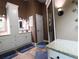 Bathroom with granite countertops, tiled floors, and glass door shower at 550 Sessingham Ct, Alpharetta, GA 30005