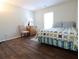 Cozy bedroom featuring wood flooring, a quilt bedspread, and lots of natural light at 550 Sessingham Ct, Alpharetta, GA 30005