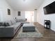 Bright living room featuring wood floors, a gray sectional, and a large wall-mounted TV at 550 Sessingham Ct, Alpharetta, GA 30005