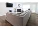 Comfortable living room showcasing a sectional sofa, TV, fireplace, and wood flooring at 550 Sessingham Ct, Alpharetta, GA 30005