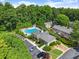Aerial view showing a pool and clubhouse with lots of surrounding trees and parking at 603 Brighton Pt, Atlanta, GA 30328