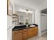 Bright bathroom with wood cabinets, dual sinks, framed mirrors, and modern lighting at 603 Brighton Pt, Atlanta, GA 30328