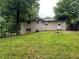 View of backyard featuring home's exterior with siding, grass lawn, trees, and an entry door at 718 Hardy Way, Hiram, GA 30141