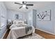 A well-lit bedroom with hard wood floors, ceiling fan, queen bed and decorative art at 1694 Pheasant Dr, Atlanta, GA 30238