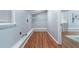 A spacious laundry room with wood plank floors and overhead wire rack for ample storage at 1694 Pheasant Dr, Atlanta, GA 30238