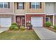 Townhome featuring brick accents, individual garages and manicured shrubbery at 2083 Hasel St, Lawrenceville, GA 30044