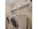 Bright laundry room with washer, dryer, and storage shelves at 2083 Hasel St, Lawrenceville, GA 30044