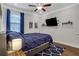 Cozy bedroom with dark blue accents, modern lighting, and a wall-mounted television at 2980 Prestwood Dr, Cumming, GA 30040