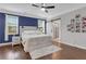 This bedroom features a blue accent wall, ceiling fan, and a sliding barn door to the bathroom at 2980 Prestwood Dr, Cumming, GA 30040