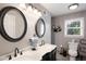 Bathroom with dual sinks with black cabinets, framed mirrors and plenty of natural light at 3359 Villa Ln, Douglasville, GA 30135