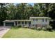 Charming two-story home with a spacious front yard and inviting front porch surrounded by lush trees at 3359 Villa Ln, Douglasville, GA 30135