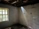 Unfinished basement features a window; in need of renovation with visible ceiling beams and exposed brick foundation walls at 372 Nalley Dr, Stone Mountain, GA 30087