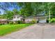 Exterior view of a house with mature trees, a carport, and a spacious driveway at 6250 Graceland Cir, Morrow, GA 30260