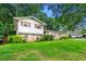 Exterior view of a house with mature trees, a well-maintained lawn, and a mix of brick and siding at 6250 Graceland Cir, Morrow, GA 30260