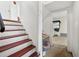 A view of a stairway with hardwood steps, neutral decor, and a glimpse into an adjacent room at 6250 Graceland Cir, Morrow, GA 30260