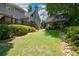 A large backyard featuring a deck, brick garage, and mature landscaping at 1464 Chatsworth Trace, Lawrenceville, GA 30044