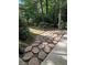 Stone path leading through a landscaped backyard with flowering bushes at 1464 Chatsworth Trace, Lawrenceville, GA 30044