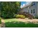 Large backyard featuring mature trees, green grass, and a deck at 1464 Chatsworth Trace, Lawrenceville, GA 30044