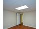 View of an unfinished basement with laminate flooring and a white door to another room at 1464 Chatsworth Trace, Lawrenceville, GA 30044