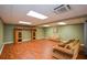 Wide open finished basement with laminate flooring, a built-in shelving unit, and comfortable seating at 1464 Chatsworth Trace, Lawrenceville, GA 30044