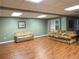 Finished basement featuring wood-look flooring, neutral paint, and comfortable seating areas at 1464 Chatsworth Trace, Lawrenceville, GA 30044