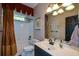 Cozy bathroom with shower-tub combination, vanity, and decorative mirror and lighting at 1464 Chatsworth Trace, Lawrenceville, GA 30044