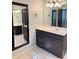 The primary bathroom offers a gray vanity with white top, black hardware, tile floors, and a large mirror at 1464 Chatsworth Trace, Lawrenceville, GA 30044