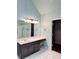 This primary bathroom offers tile floors, a single vanity and a large mirror, accented with sleek lighting at 1464 Chatsworth Trace, Lawrenceville, GA 30044