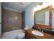 Well-lit bathroom with a tiled shower, granite countertops, and modern fixtures at 1464 Chatsworth Trace, Lawrenceville, GA 30044