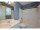 Bathroom featuring a tub, shower, and single sink vanity with a large mirror and window at 1464 Chatsworth Trace, Lawrenceville, GA 30044