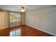 Comfortable bedroom with hardwood floors, a window and a ceiling fan for a relaxing space at 1464 Chatsworth Trace, Lawrenceville, GA 30044
