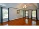 Spacious bedroom featuring tray ceiling, a ceiling fan, hardwood floors and large windows at 1464 Chatsworth Trace, Lawrenceville, GA 30044