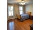 Cozy bedroom features wood floors, a ceiling fan, and lots of natural light at 1464 Chatsworth Trace, Lawrenceville, GA 30044