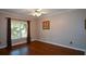 Bright bedroom with hardwood floors, window with curtains, and neutral paint at 1464 Chatsworth Trace, Lawrenceville, GA 30044