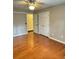 This bedroom features hardwood floors, a ceiling fan and a double-door closet for storage at 1464 Chatsworth Trace, Lawrenceville, GA 30044