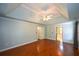 Large bedroom with a tray ceiling, fan and hardwood flooring, leading to a walk-in closet at 1464 Chatsworth Trace, Lawrenceville, GA 30044