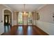 Formal dining area featuring an elegant chandelier, windows, and hardwood floors at 1464 Chatsworth Trace, Lawrenceville, GA 30044