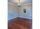 Empty room with hardwood floors, neutral walls, and modern light fixture at 1464 Chatsworth Trace, Lawrenceville, GA 30044