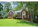 Charming two-story brick home with manicured lawn, mature trees, and inviting front entrance at 1464 Chatsworth Trace, Lawrenceville, GA 30044