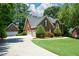 Spacious home featuring a three-car garage, driveway, and manicured lawn at 1464 Chatsworth Trace, Lawrenceville, GA 30044