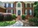 Inviting front entrance with brick steps, lush landscaping, and decorative front door at 1464 Chatsworth Trace, Lawrenceville, GA 30044